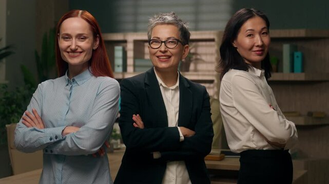 Happy three confident successful multinational diverse women businesswomen business office portrait crossed hands professionals females team smiling colleagues employees co-workers indoors managers