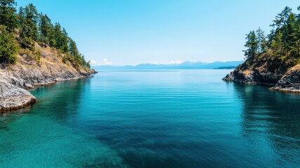 Fototapeta premium A serene view of calm turquoise waters surrounded by lush greenery and distant mountains under a clear blue sky.