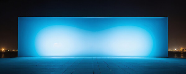 Fototapeta premium Bright blue illuminated wall at night near a waterfront with distant city lights visible