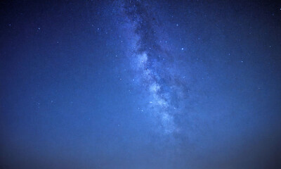 Night sky filled with stars over a calm landscape in a remote area
