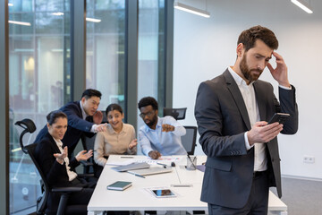 Diverse people colleagues at workplace inside office discussing boss behind back, sneering and...