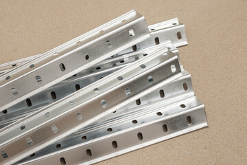 Perforated metal profile corners for adjustable shelving unit on beige background