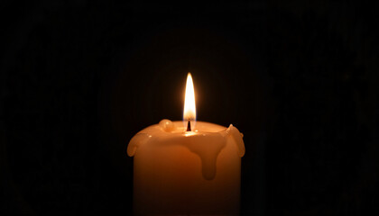 Soft candle flame illuminating darkness, symbol of serenity