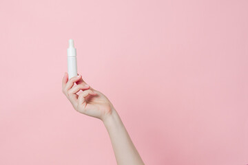 Glass unbranded bottle with serum or essential oil with pipette on gentle background. Presenting luxury skincare products