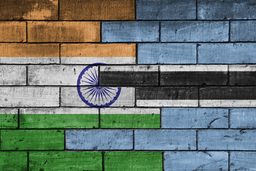 colourful painted big flag of india and flag of botswana on a massive old brick wall background....