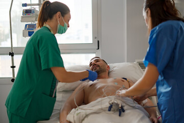 Obraz premium nurses performing electrocardiogram on a patient in ICU