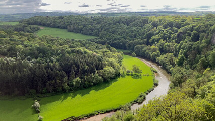 Scenic view of a lush green valley from Symonds Yat Rock with a winding river bordered by dense woodlands, representing serene natural beauty in peaceful rural surroundings - Herefordshire, UK