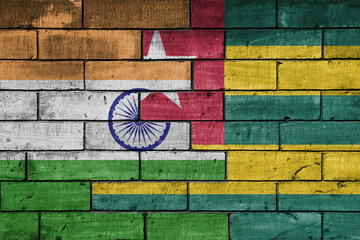 colourful painted big flag of india and flag of togo on a massive old brick wall background. concept