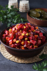 Traditional salad Vinaigrette of beets, potatoes, carrots, corn, pickles, onions and vegetable oil on gray background. Vegetarian food