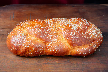 Easter sweet bread, homemade tsoureki braid on wooden table, closeup