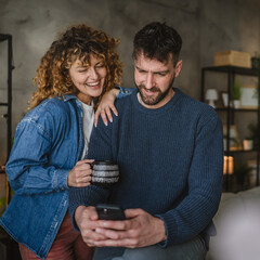 Portrait of boyfriend use mobile while his girlfriend hug and kiss him
