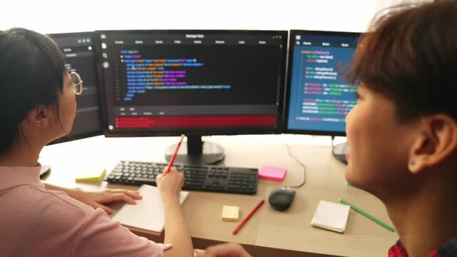 Back end software developer engineer for computer programming working together on debugging writing computing code, solving complex algorithms display on monitor in office. Burgeoning