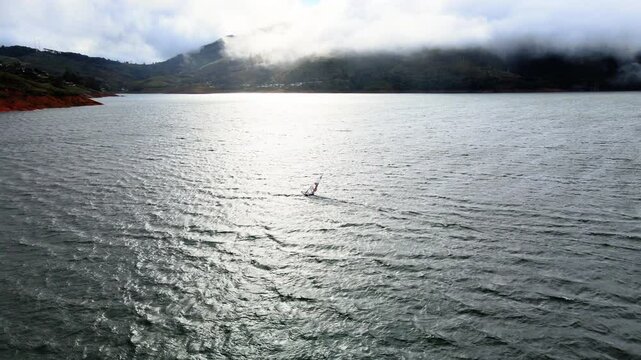 windsurfing at sunset in lake calima