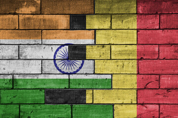 colourful painted big flag of india and flag of belgium on a massive old brick wall background. concept