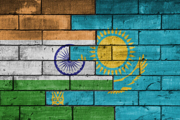 colourful painted big flag of india and flag of kazakhstan on a massive old brick wall background. concept