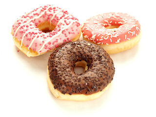 Three donuts stacked on top of each other with pink frosting and sprinkles. The donuts are piled high and look delicious. Internationally popular pastry product. Perfect desert.