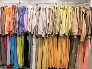 Colorful display of cozy sweatshirts hanging in a trendy clothing store