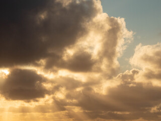 Dark dramatic sunset sky with clouds and sun beams and flare. Nature background for design and sky replacement.