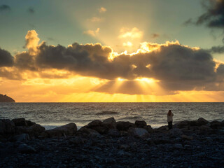 Silhouette of a woman looking at dramatic cloudy sky which looks like a monster with eyes and...