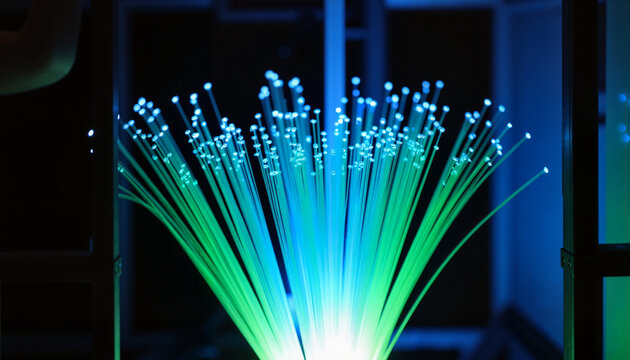 Glowing optical fibers radiating vibrant blue and green light, photonics