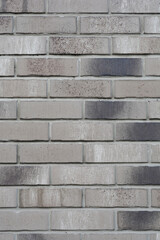 A wall of gray decorative brick with darker patches, forming a textured surface