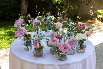 arreglos florales en frascos de vidrio para una ceremonia