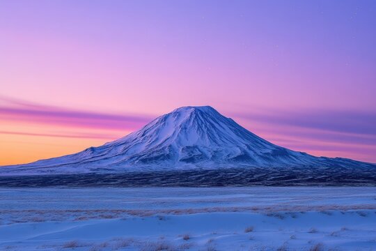 Majestic snow-capped mountain at sunset, serene winter landscape under a vibrant purple sky.