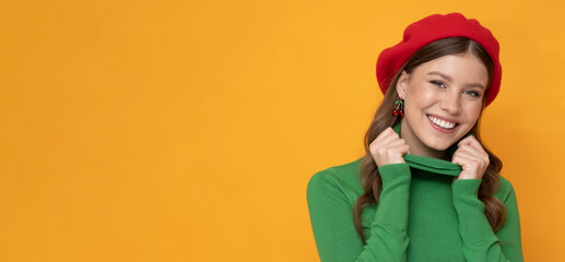 Happy and positive young woman in red beret on isolated orange background.