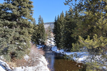 Snow covered banks of Gore Creek in Vail, Colorado on a winter day