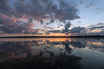 Beautiful reflection of dawn clouds in the calm waters of the Amazon River. State of Amazonas,...