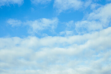 Blue sky with fluffy clouds. Celestial calm background, pure colors