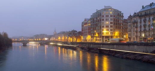 Naklejka premium Cityscape of Grenoble with Isere river at winter twilight