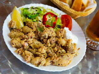Spanish seafood dish chipirones a la andaluza, battered squid served with fresh vegetable salad