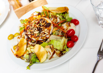 Tasty goat cheese salad with fresh greens, pear, nuts and soy sauce. Spanish cuisine