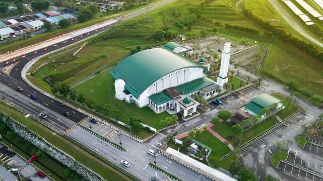 4K aerial view of Masjid Perodua, Bukit Beruntung, surrounded by housing, roads, and greenery, featuring a green roof and spacious parking.