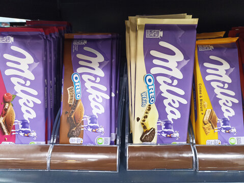 Assorted milka chocolate bars display with oreo and biscuit flavors on shelf