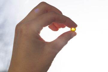 Closeup of vitamin D capsule. Concept of supplementing vitamin D in winter.