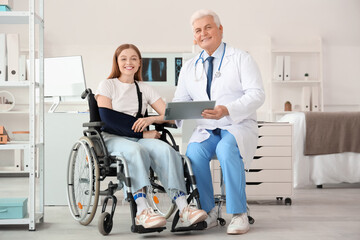Young woman in wheelchair with broken arm visiting doctor at hospital