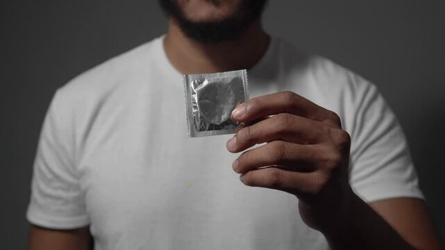 Man showing wrapped condom in hand