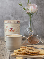 Still life of homemade heart-shaped cookies along with a coffee and kitchen utensils. Romantic snack