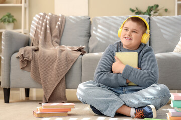 Little boy with headphones and books at home