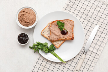 Plate with toasts, bowl of tasty pate, parsley and sauce on light background