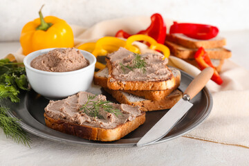 Plate with toasts, bowl of tasty pate, dill and knife on light background
