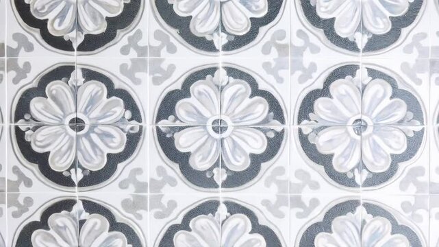Tile floor with a pattern of flowers. The tiles are white and black. The floor is tiled in a way that the flowers are spread out in a grid