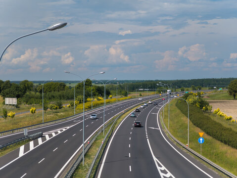 Summer landscape view of cars moving on the freeway (highway) road between Poznan and Bydgoszcz (Droga ekspresowa S5) in Wielkopolska, Poland