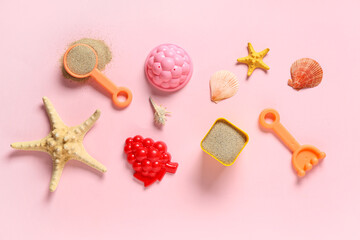 Beach toys, starfishes, seashells and sand on pink background