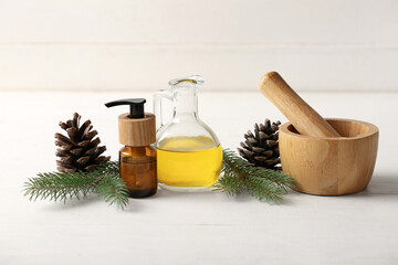 Coniferous cone essential oil on white wooden background