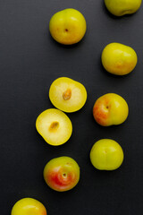 Fresh green plum fruit on dark background.