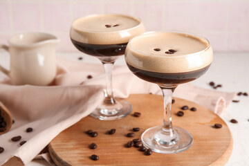 Glasses of hot coffee and beans on white table