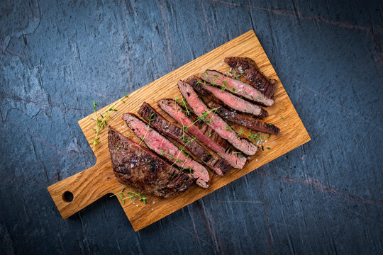 Barbecue grilled dry aged meat wagyu beef flank steak cut as tagliata on wooden board with text space